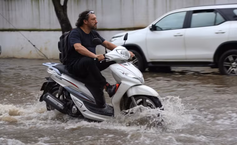 Người nước ngoài chạy xe máy qua tuyến đường ngập nước ở phường Thảo Điền chiều 28/9.