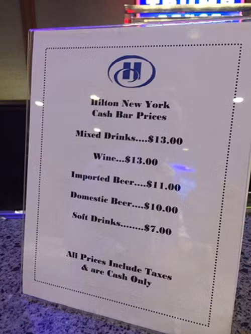 Được biết, trong bữa tiệc, người tham dự sẽ phải tự mua đồ uống. Giá cả một số loại đồ uống như rượu là 13 USD, bia nhập khẩu 11 USD, bia nội địa 10 USD hay nước ngọt 7 USD. Ảnh: Bảng giá đồ uống trong tiệc mừng của ông Donald Trump tại khách sạn Hilton. (Nguồn: Twitter).