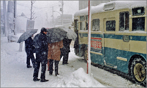 Mọi người lên xe buýt giữa trời tuyết rơi trắng xóa ở Tokyo hàng chục năm về trước.