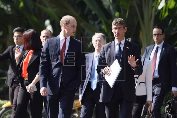 Hoàng tử Anh trao đổi với một quan chức khi đi dạo trong Phủ Chủ tịch ở thủ đô Hà Nội hôm 16/11. Ảnh: EPA/Luong Thai Linh.