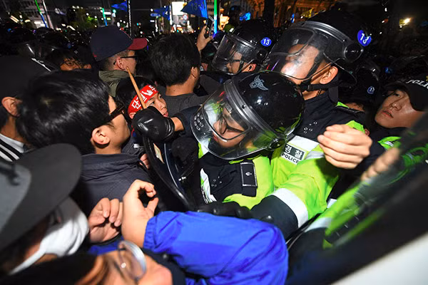 Người biểu tình đụng độ với cảnh sát chống bạo động Hàn Quốc khi họ tuần hành tới Nhà Xanh ở thủ đô Seoul hôm 29/10/2016 trong cuộc biểu tình yêu cầu Tổng thống Park Geun-hye từ chức.