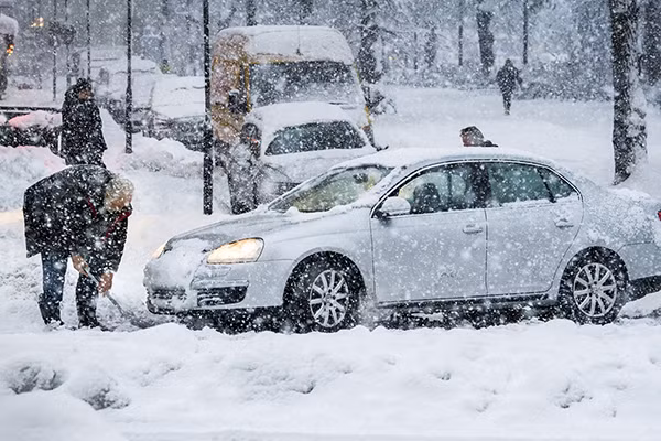 Tại thủ đô Stockholm của Thụy Điển, tuyết rơi dày ít nhất 10 cm. Ảnh: Một người đàn ông đang dùng xẻng dọn tuyết trên đường. (Nguồn: EPA).
