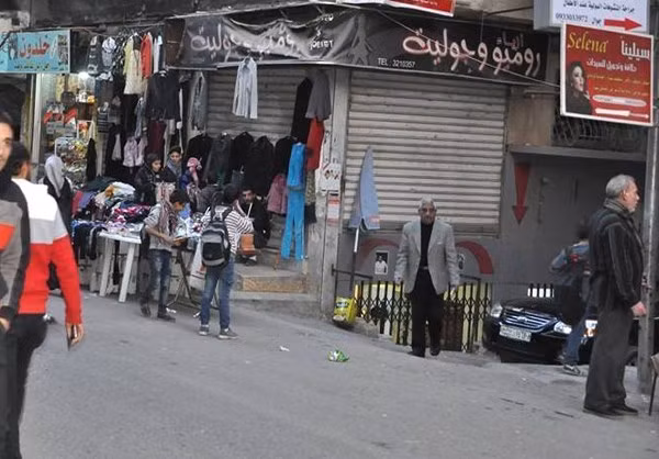 Người dân xem quần áo được bày bán ngoài đường phố ở Ghouta, ngoại ô thủ đô Syria. Ảnh: FNA.