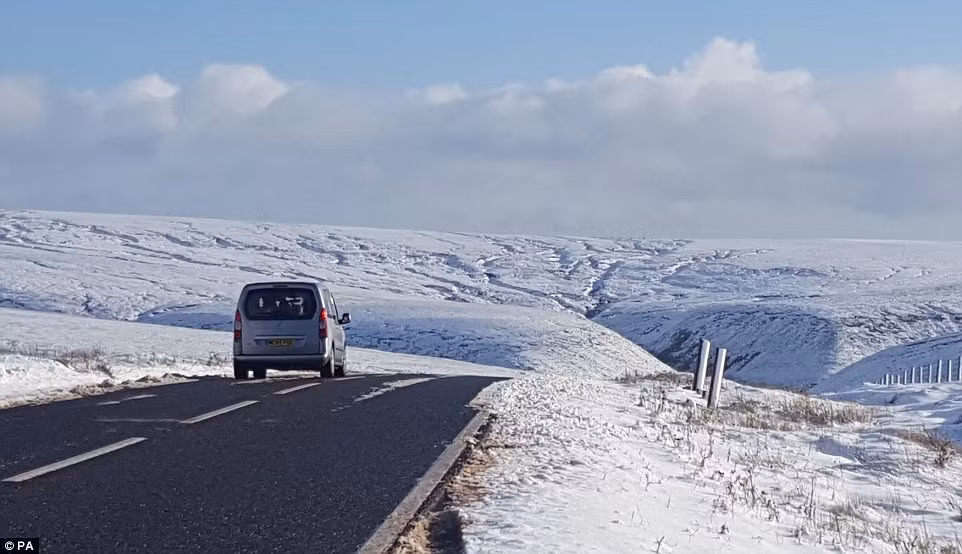 Một chiếc ô tô đi trên con đường đèo Snake. Tuyết trắng xóa bao trùm cả khu vực rộng lớn.