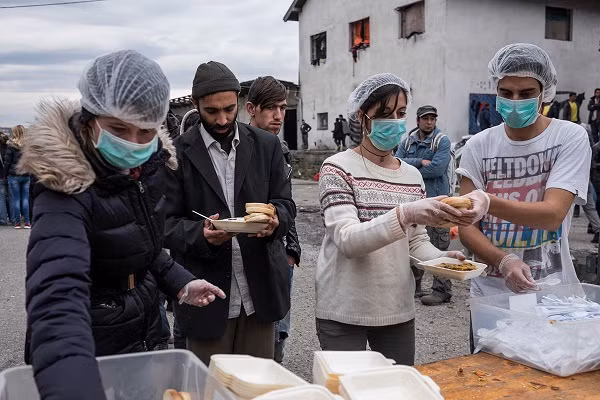 Một nhóm tình nguyện viên đang phân phát đồ ăn cho người tị nạn.