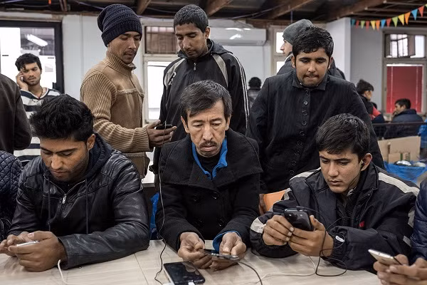 Các di dân sạc pin điện thoại ở trung tâm Miksaliste. Họ đến đây vào ban ngày còn ban đêm thì ra ngoài công viên hoặc vào trong những tòa nhà bỏ hoang để ngủ.