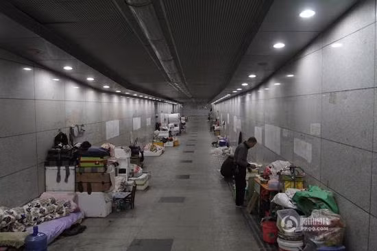 Khoảng 10 người vô gia cư đang sống trong đường hầm dành cho người đi bộ ở thành phố Vũ Hán, tỉnh Hồ Bắc. Họ nghỉ ngơi và ăn uống ngay trong đường hầm. Ảnh: Sina.