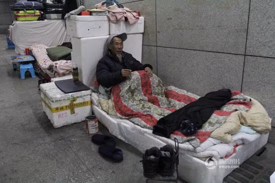 Giường ngủ của một cụ ông có vẻ khá ấm áp, với đầy đủ chăn, đệm. Ảnh: Sina.