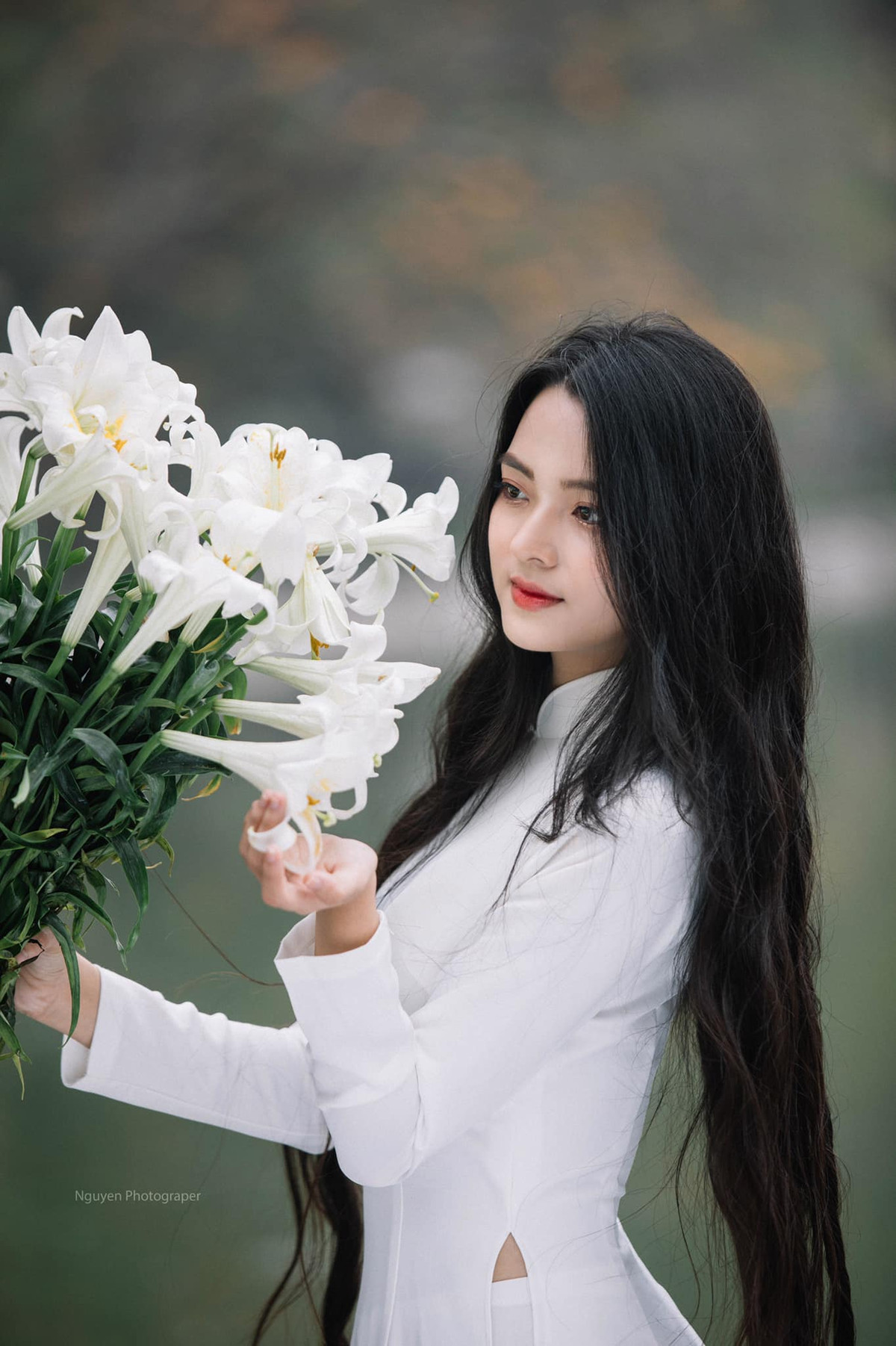 Mới đây nàng hot girl đất Quảng Nam gây ấn tượng khi cho ra mắt bộ ảnh áo dài trắng bên hoa loa kèn cùng mái tóc đen suôn dài.