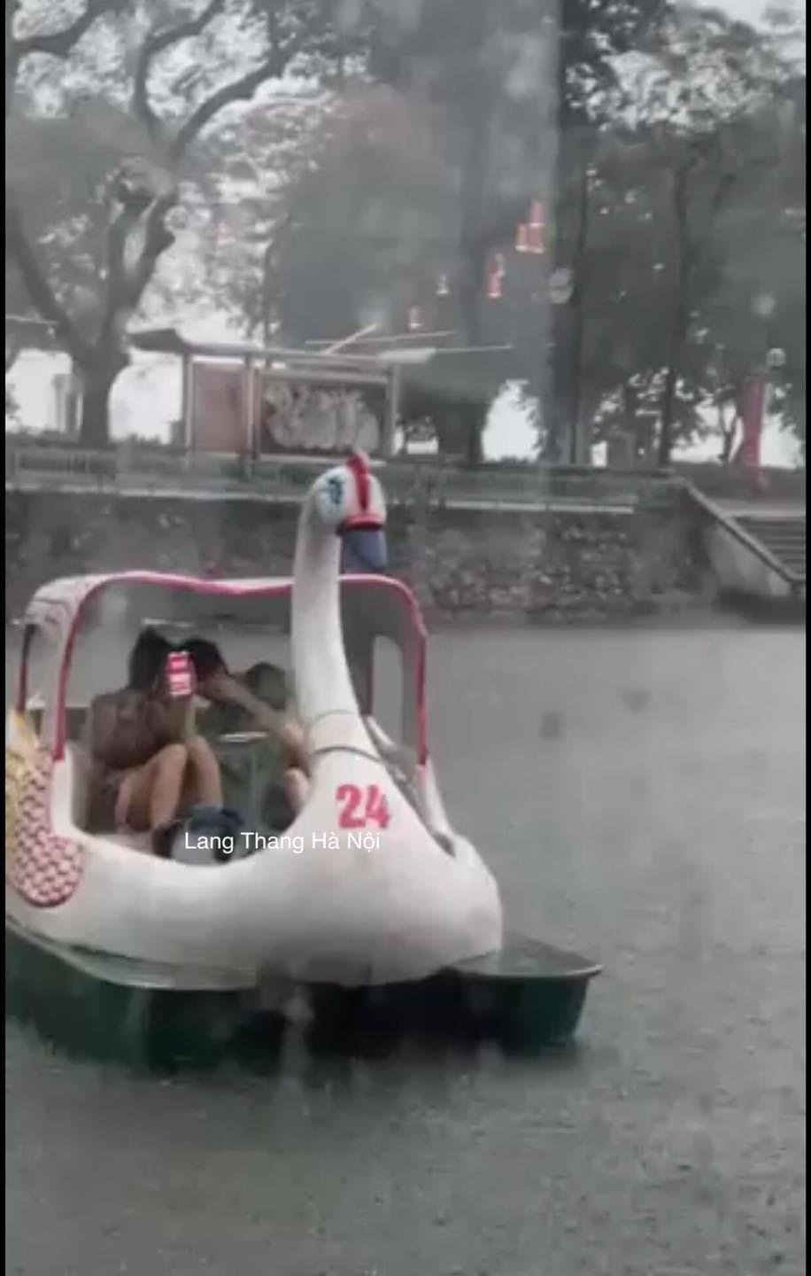 Một cặp đôi đang đạp vịt giữa trời mưa tầm tã. Ảnh: Mai Nguyễn - Lang Thang Hà Nội