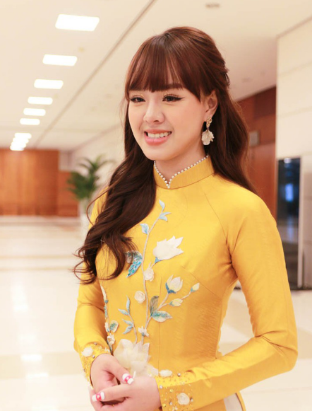 Đảm nhận vai trò MC, Thảo Trang diện áo dài màu vàng, dưới ánh đèn sân khấu, áo dài truyền thống trở nên nổi bật hơn bao giờ hết