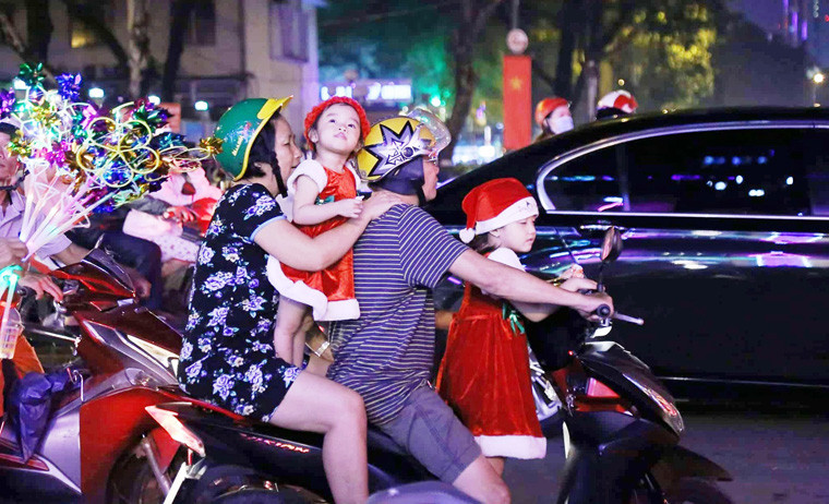 Nhiều đứa trẻ xúng xính trong bộ quần áo Noel với vẻ mặt vô cùng hớn hở cùng người thân xuống đường đón Giáng sinh.