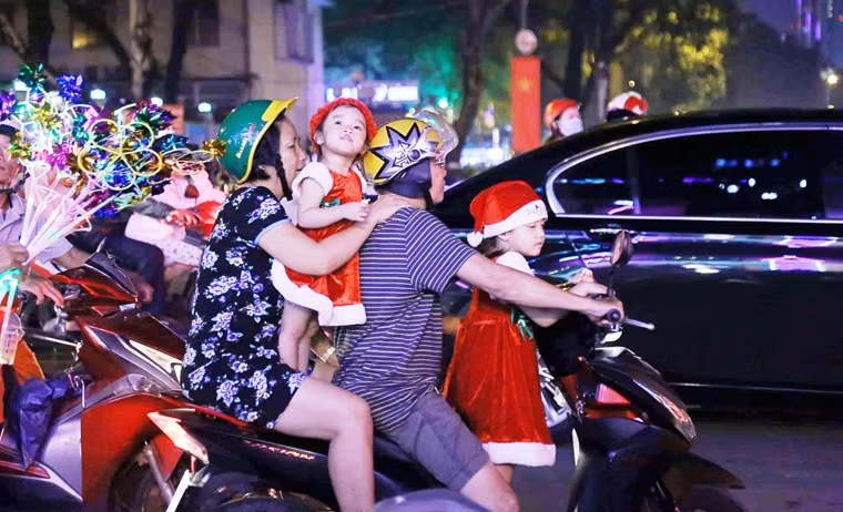 Nhiều đứa trẻ xúng xính trong bộ quần áo Noel với vẻ mặt vô cùng hớn hở cùng người thân xuống đường đón Giáng sinh.