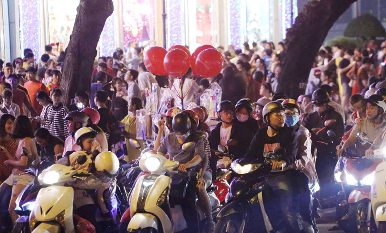 Trong tiết trời mát mẻ khá lý tưởng trong đêm Giáng sinh 24/12, "biển người" tấp nập xuống phố đón Giáng sinh tập trung về các tuyến phố chính, những trung tâm thương mại, điểm vui chơi, nhà thờ để chào đón Giáng sinh 2018 tạo nên không khí vô cùng hân hoan và ấm áp.