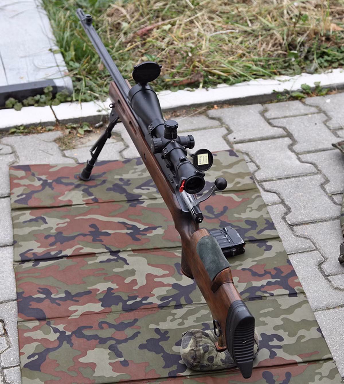 Báng súng dù làm bằng gỗ nhưng lại có khả năng điều chỉnh chiều dài và chiều cao khu vực tì má như những loại báng súng hiện đại làm bằng nhựa tổng hợp ngày nay. Đây là thiết kế khá đáng tiền của MTs-116M dù rằng cơ cấu chuyển động với vật liệu gỗ chắc chắn sẽ có độ bền không cao bằng vật liệu tổng hợp. Nguồn ảnh: Wikipedia.