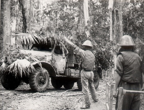 Xe vận tải được nguỵ trang khi di chuyển dọc tuyến Đường Trường Sơn, lính lái xe tải được trang bị mũ sắt và áo giáp để hạn chế bớt thương vong khi bị máy bay Mỹ oanh tạc. Nguồn ảnh: TL.