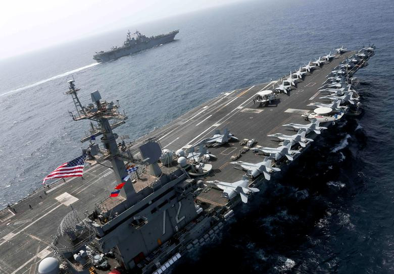 Tàu sân bay USS Abraham Lincoln (gần) và tàu đổ bộ tấn công USS Kearsarge đều thuộc biên chế Hạm đội 5 Hải quân Mỹ. Nguồn ảnh: Reuters.