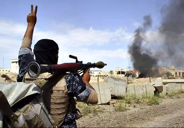 Một người lính Iraq giơ cao biểu tượng chiến thắng trên một con đường vào thị trấn Badush, trong chiến dịch giải phóng Tây Mosul từ tay phiến quân IS. Ảnh FNA