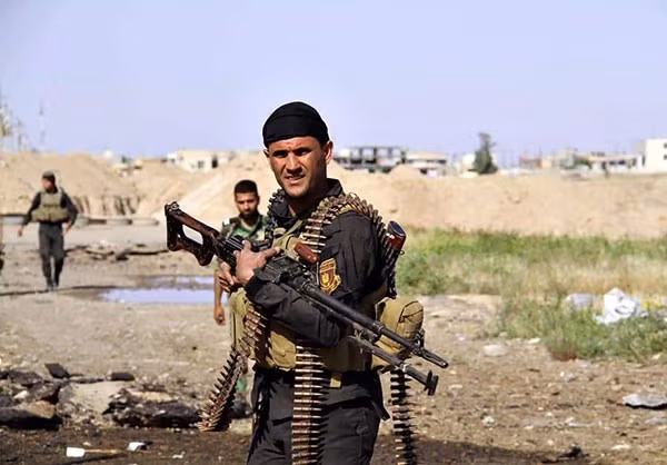 Một người lính Iraq với băng đạn súng máy quấn quanh mình. Ảnh FNA