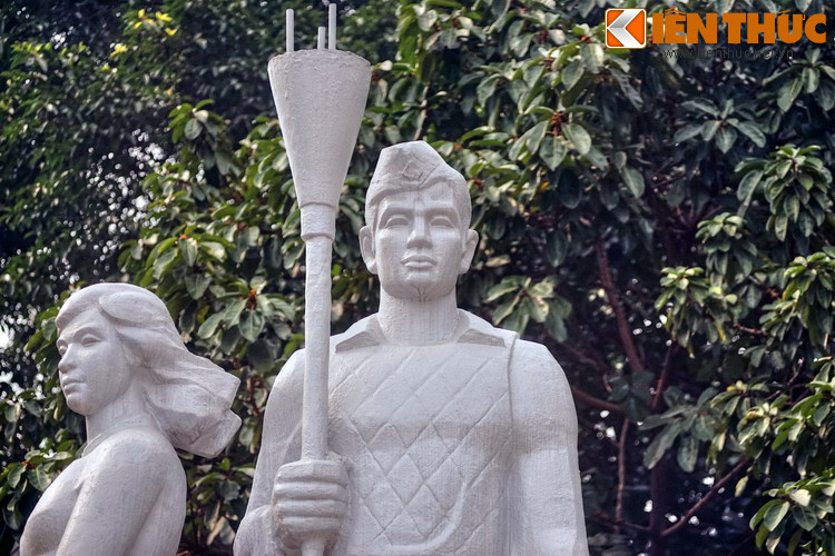 Tay phải của anh cầm bom ba càng, một biểu tượng cho tinh thần cảm tử trong những ngày Toàn quốc kháng chiến.