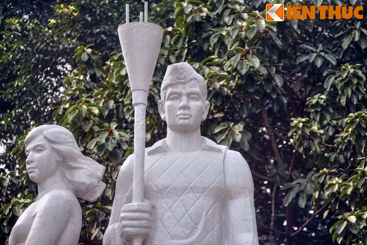 Tay phải của anh cầm bom ba càng, một biểu tượng cho tinh thần cảm tử trong những ngày Toàn quốc kháng chiến.