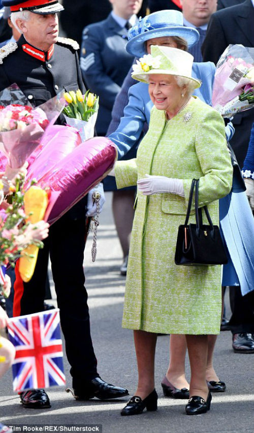 Nữ hoàng Anh cười tươi khi nhận những bó hoa tươi thắm của người dân.