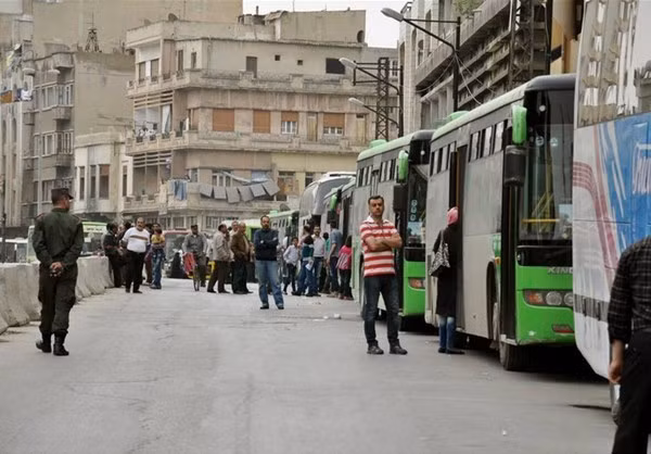 Người dân chờ đợi để được lên xe buýt trở về quê hương trong niềm hân hoan.