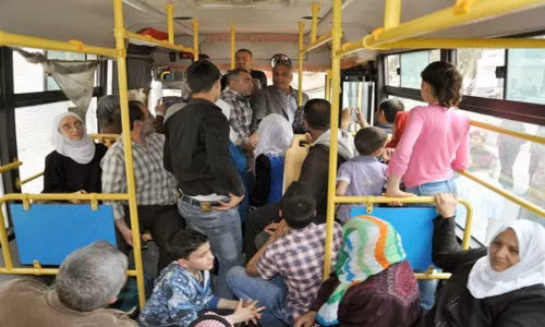 Cảnh tượng đông đúc trên xe buýt tại Syria. Mọi người hào hứng nói chuyện với nhau.