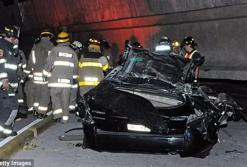 Lực lượng cứu hộ tập trung gần một chiếc ô tô bị hư hại sau khi một cây cầu đổ sập.