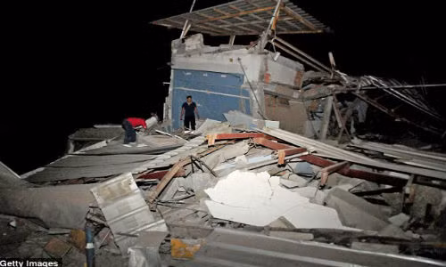 Người dân kiểm tra một ngôi nhà bị phá huỷ sau trận động đất.