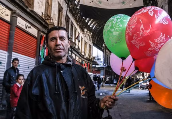 Người đàn ông bán bóng bay trên đường phố Damascus.