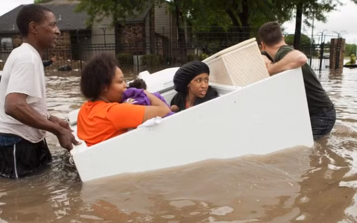 Các cư dân ở khu chung cư Arbor Court ngồi vào chiếc tủ lạnh và được đưa ra khỏi khu vực ngập lụt.