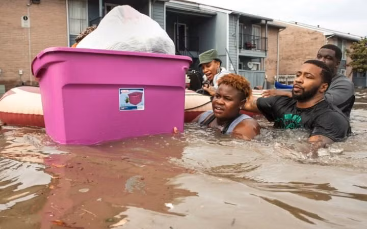 Người dân ở Texas "bì bõm" trong nước lũ.