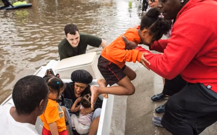 Các em nhỏ được đưa ra khỏi khu vực bị ngập.