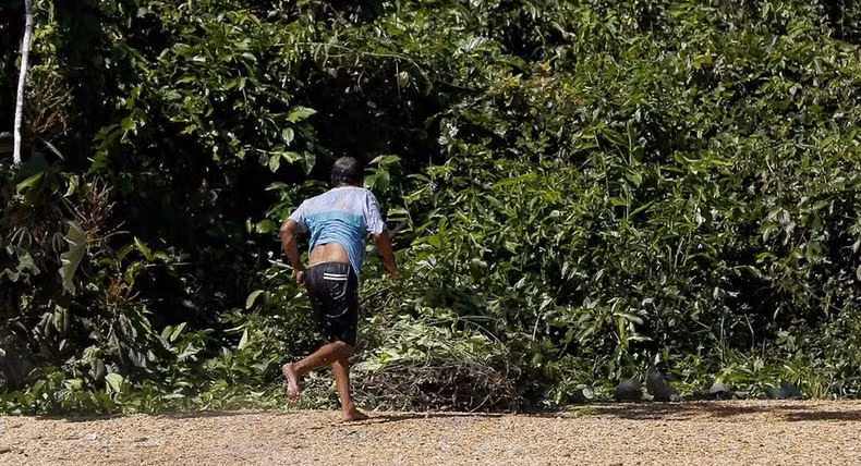 Một thợ mỏ khai thác vàng trái phép đang bỏ chạy.