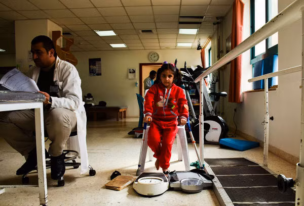 Mariam Abd el-Hadi el-Ghantawi, 5 tuổi, đang được làm vật lý trị liệu tại bệnh viện. Cô bé bị thương trong một vụ nổ ở tỉnh Homs, Syria.