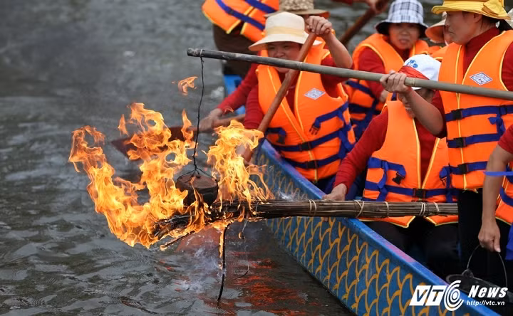 Thi nấu cơm, người thi ngồi trên thuyền, niêu cơm được buộc vào thanh đòn, thả trên ngọn lửa được đốt bởi một bó đóm dài. Khi nấu cơm sẽ có đội “phá đám” hay “thử tài” ngồi trên thuyền khác, lấy tay lay thuyền, làm cho thuyền tròng trành liên tục. Chưa hết, người “phá đám” còn té nước vào thuyền để dập tắt lửa. (Ảnh: Quang Minh)