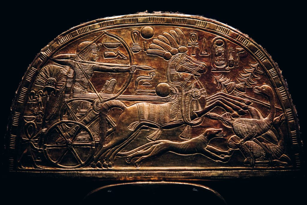 Cận cảnh một chiếc quạt được làm từ gỗ mạ vàng với những chi tiết phức tạp.