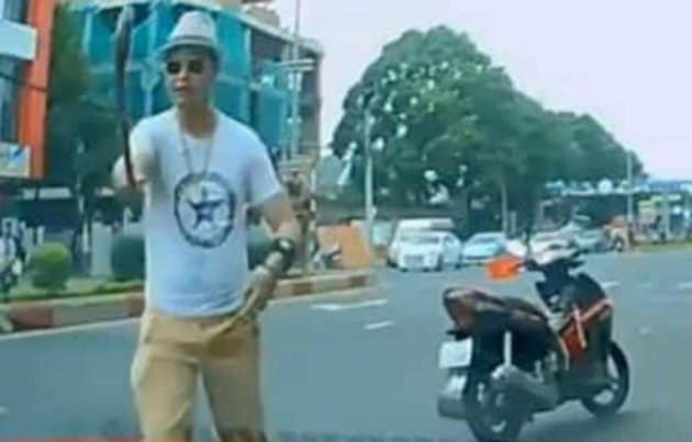 Thầy chùa mặc đồ như dân chơi sành điệu vác gậy đập vỡ kính xe ô tô của người đi đường. Ảnh: Cắt từ Clip.