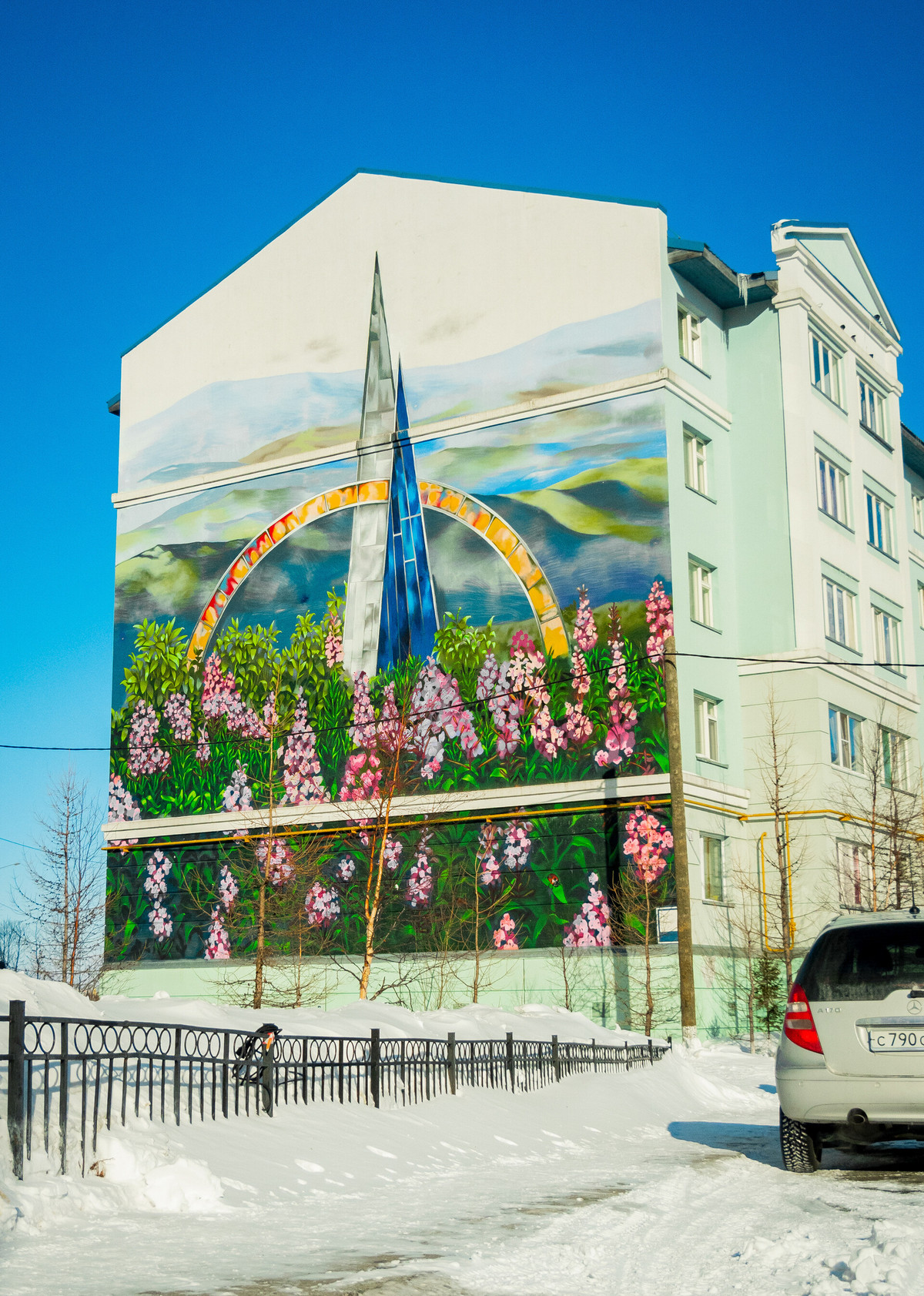 6. Tượng đài 'Vĩ tuyến 66' giữa muôn hoa: Salekhard là thành phố duy nhất trên thế giới nằm ngay trên Vòng Bắc Cực. Điểm bắt đầu của Bắc Cực được đánh dấu bằng một tượng đài hình tấm bia có tên là 'Vĩ tuyến 66'. Bức tranh tường vẽ 'Vĩ tuyến 66' trong khung cảnh hoa xuân nằm trên tường của một trong những ngôi nhà ở quận Izumrudny.