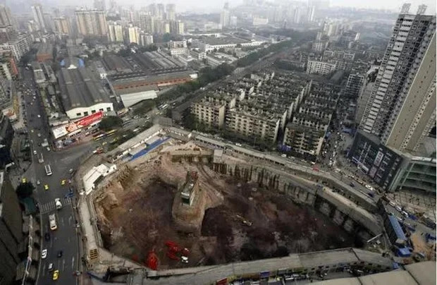 Vì không đạt được thoả thuận đền bù, ngôi nhà nhỏ nằm đơn độc giữa một hố đất sâu 10m tại số 17 đường Hạc Hưng, Dương Gia Bình, quận Cửu Long Pha, thành phố Trùng Khánh.