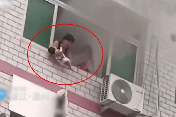 Bà mẹ bất lực ném con khỏi cửa sổ toà nhà đang cháy Ba me bat luc nem con khoi cua so toa nha dang chay