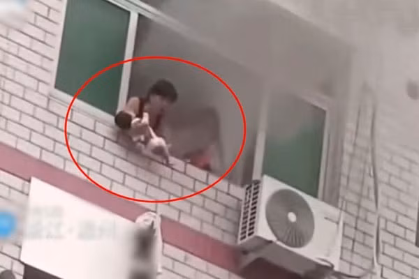 Ba me bat luc nem con khoi cua so toa nha dang chay