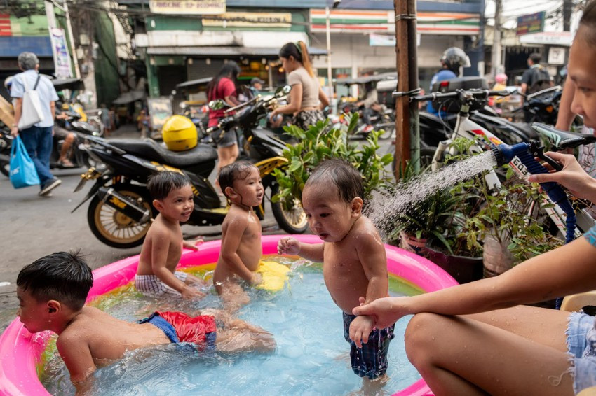Trong hình là trẻ em chơi trong một phao bơi bên cạnh một con phố ở Manila (Philippines) hồi tháng 3. Ảnh: REUTERS.
