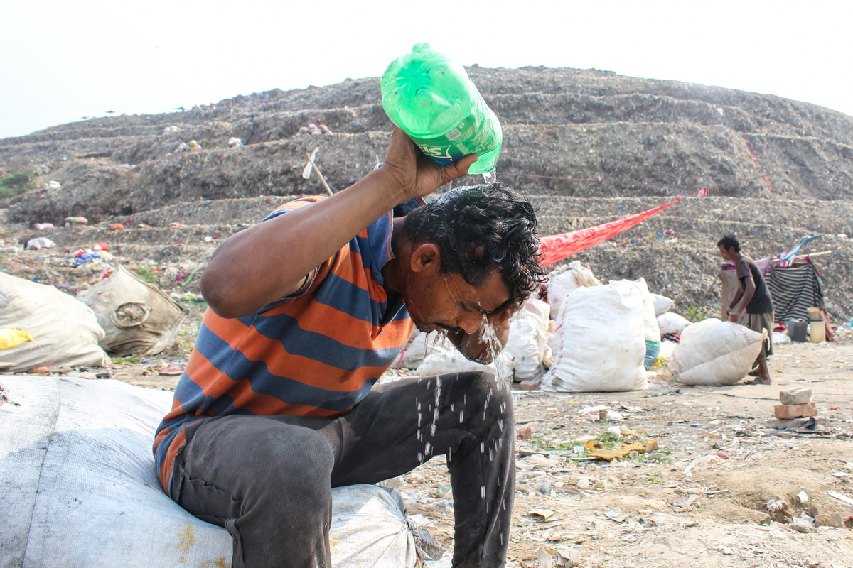 Anh Mohammed Tabraiz, một công nhân thu gom rác, phải dội nước lên đầu để làm mát sau khi làm việc cả ngày dưới trời nắng nóng tại một bãi rác ở khu phố Bhalswa, New Delhi. Ảnh: Jazeera.