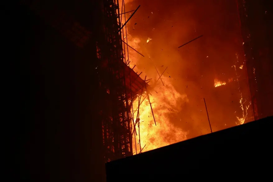 Than từ giàn giáo đã văng tung tóe rơi xuống đường khiến ít nhất hai người dưới đất bị thương.