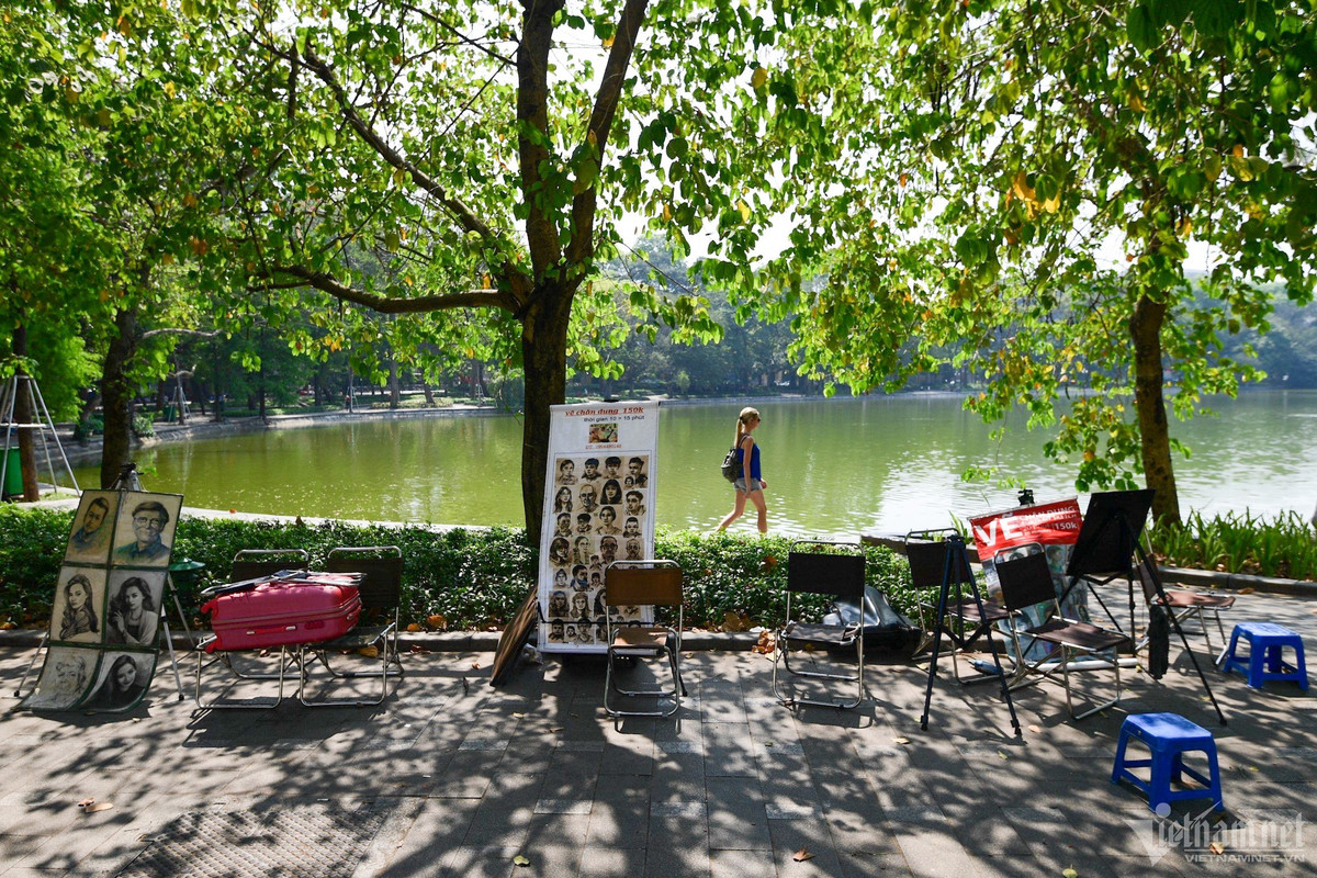 Những người hành nghề phác họa chân dung kiên nhẫn chờ khách. “Thời tiết nắng nóng, cứ bày ra vậy thôi chứ cũng không có ai tới, phải chiều tối thời tiết mát mẻ hơn thì may ra”, một họa sĩ ngồi trú trong bóng cây nói.