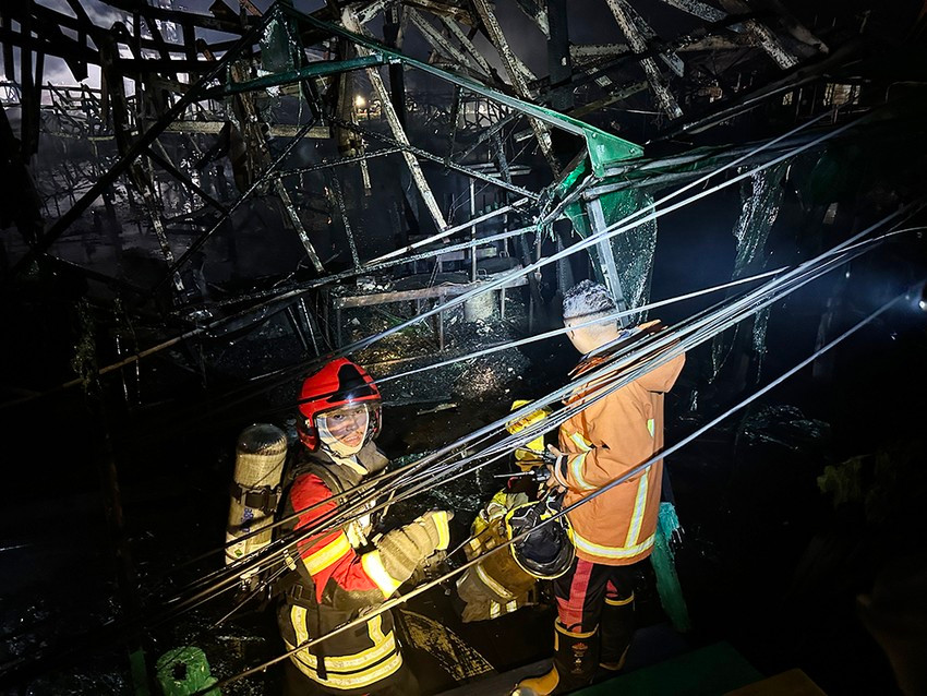 Lính cứu hỏa làm việc tới đêm khuya để chữa cháy ở chợ nổi Pattaya.