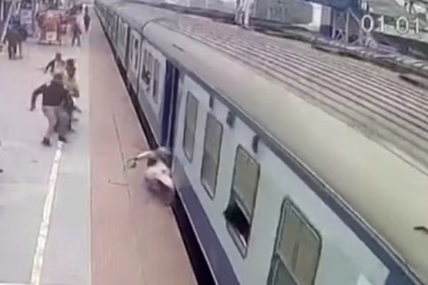 Nhan vien dung cam cuu hanh khach ket duoi doan tau dang chay