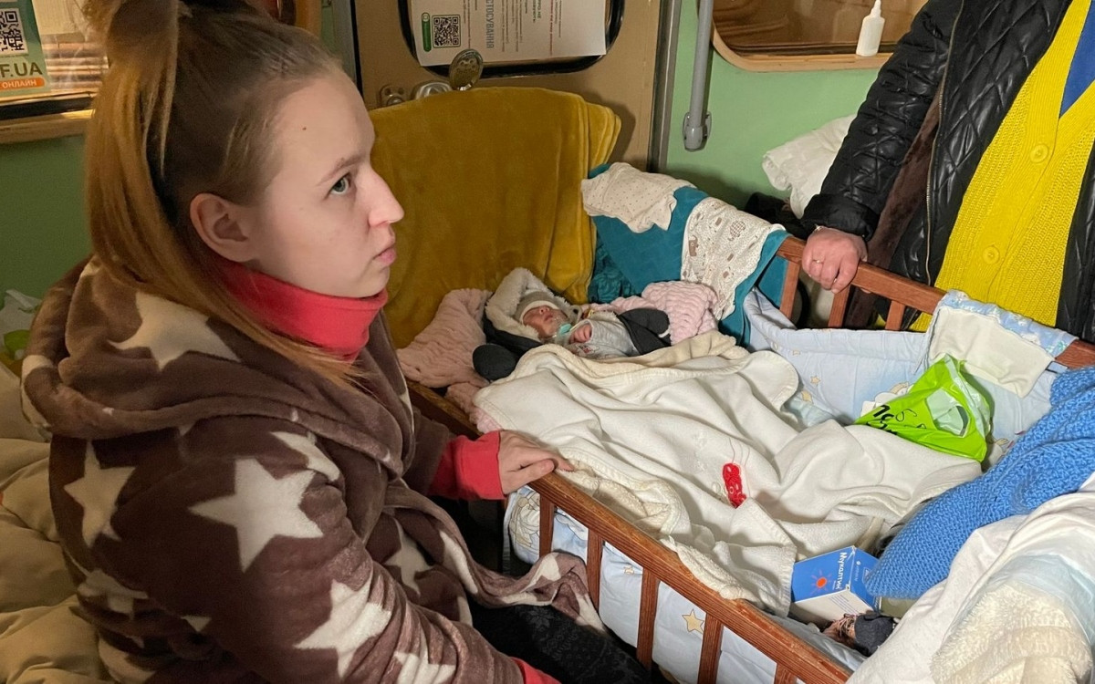 Natalya Chernobay chăm sóc con trong cũi ở dưới ga tàu điện ngầm. Ảnh: Sky News.